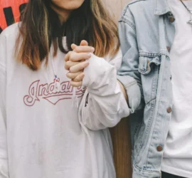 Zwei Personen halten Händchen und symbolisieren ihre Verbindung